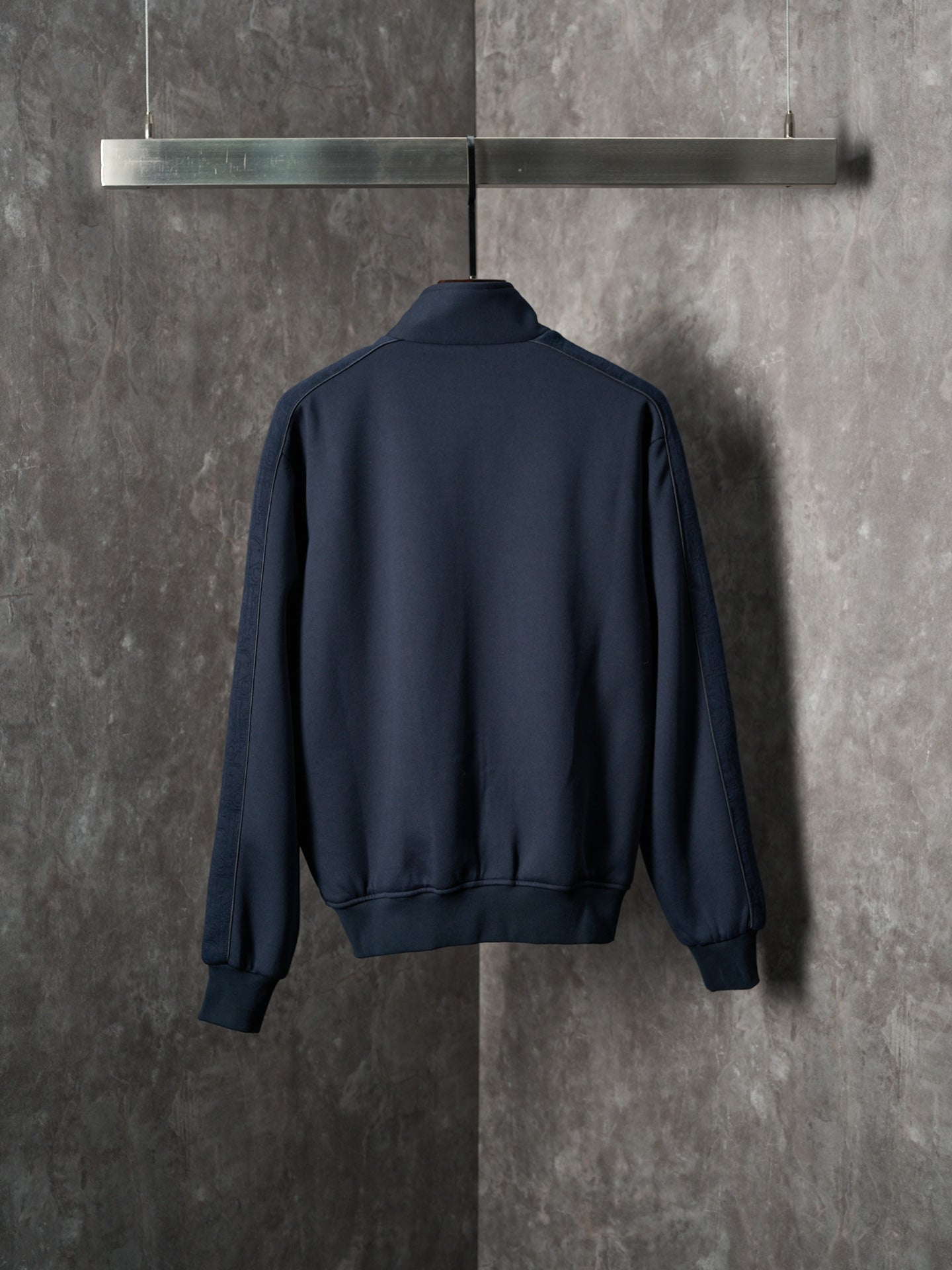 Navy back view zip-up jacket with ribbed cuffs and waistband