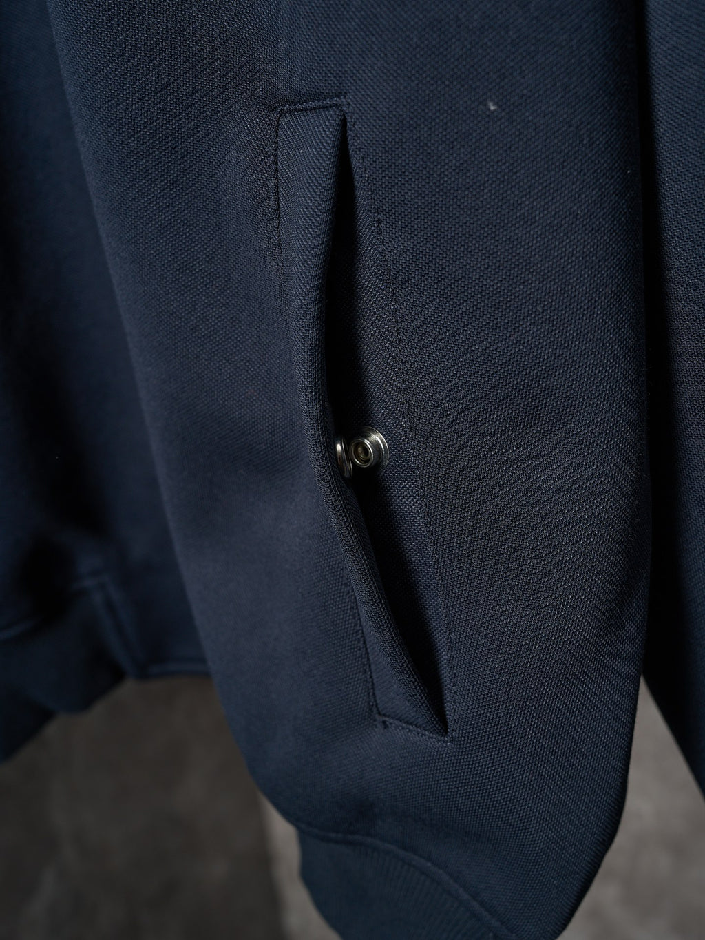 Navy jacket button placket detail on side seam pocket