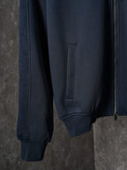 Navy jacket side view with front pocket and ribbed cuffs