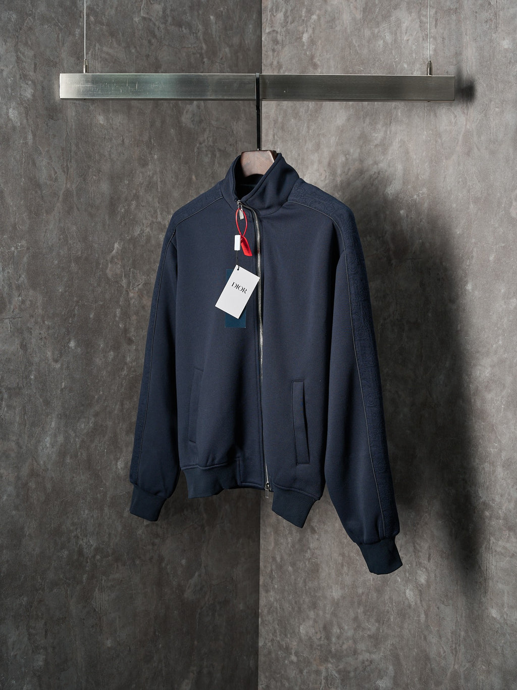 Navy zip-up jacket with stand collar, zipper front, and hanging tags