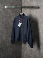 Navy zip-up jacket with stand collar, zipper front, and hanging tags
