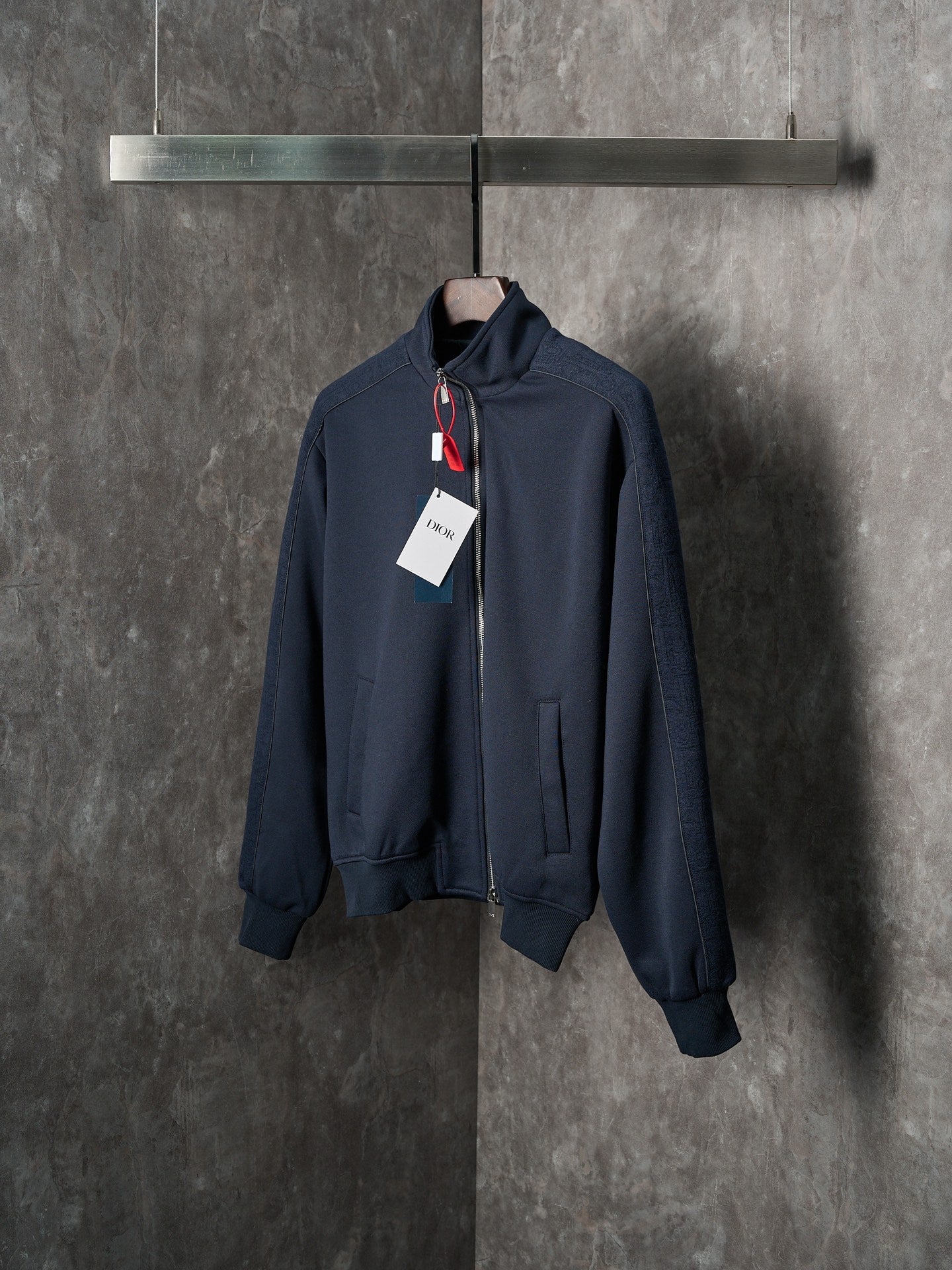 Navy zip-up jacket with stand collar, zipper front, and hanging tags