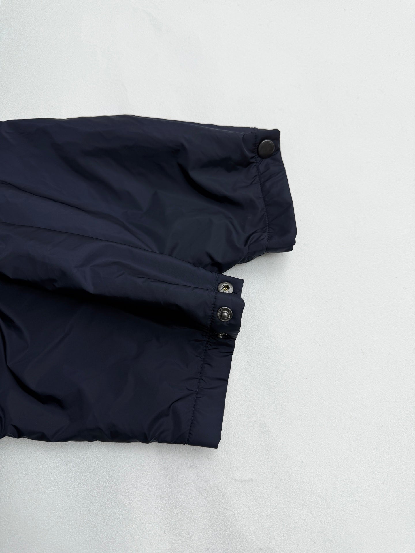 Prada dark navy jacket cuff with snap buttons and folded sleeve hem