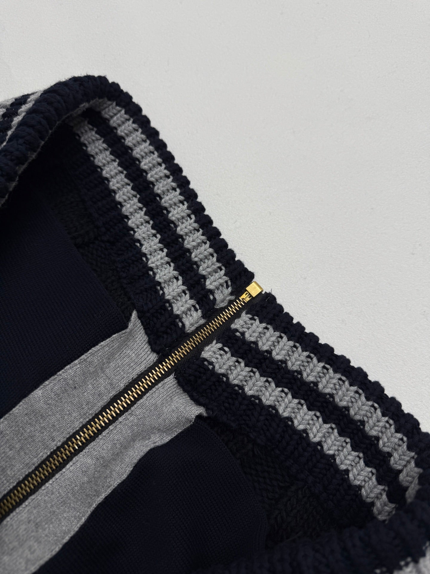Louis Vuitton knit cardigan zipper area with navy stripes and gold zip pull