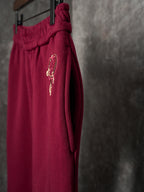 Maroon Gucci sweatpants with embroidered horsebit-style logo on the side