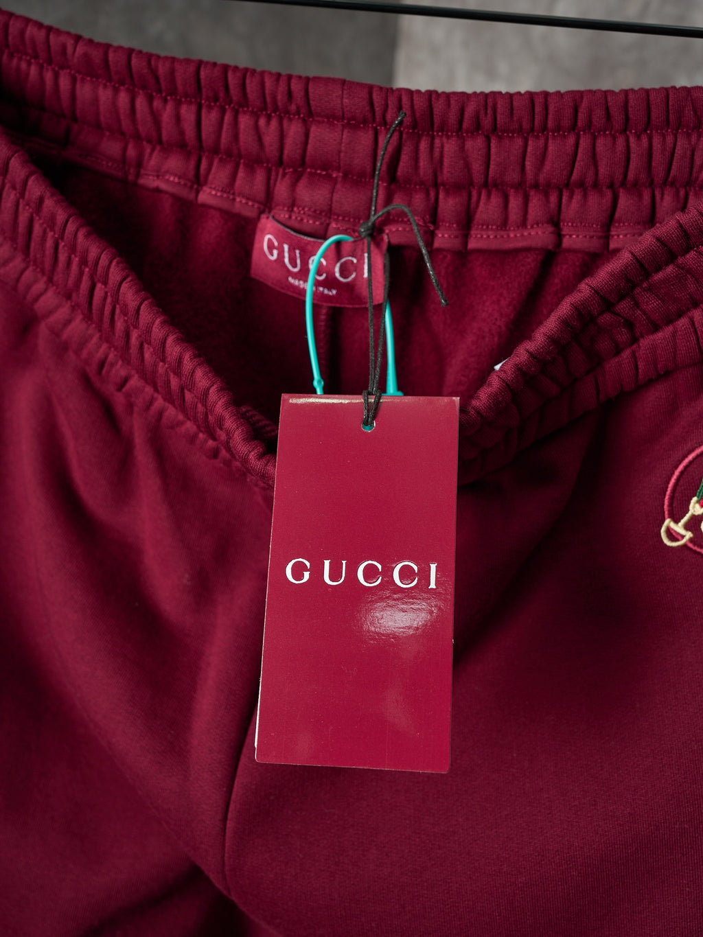 Maroon Gucci sweatpants waist with gathered elastic and attached brand tags