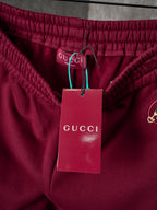 Maroon Gucci sweatpants waist with gathered elastic and attached brand tags