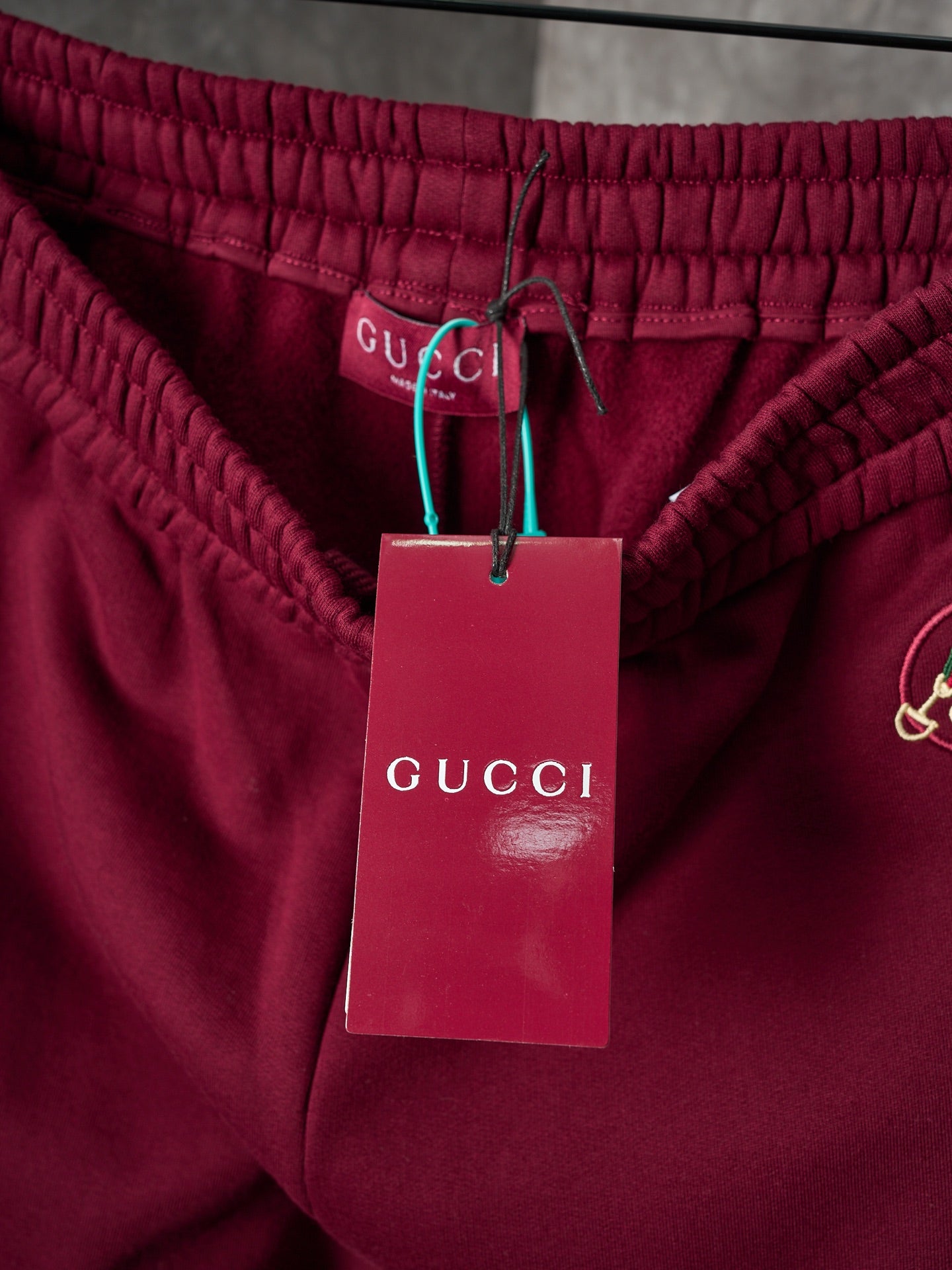 Maroon Gucci sweatpants waist with gathered elastic and attached brand tags