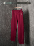 Maroon Gucci sweatpants with elastic waist and small embroidered logo on hip