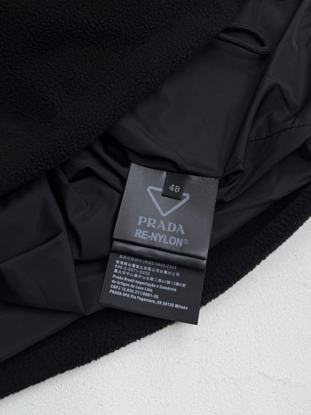 Black jacket interior label: PRADA RE-NYLON, size 48