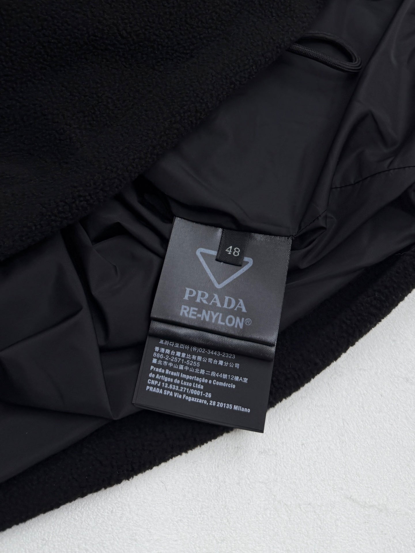 Black jacket interior label: PRADA RE-NYLON, size 48