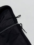 Black jacket with adjustable drawstring near zipper