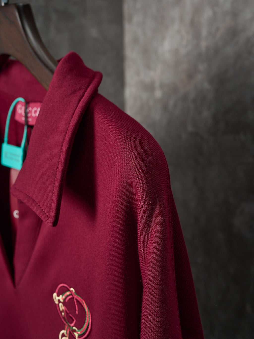 Burgundy polo sweatshirt with collar and gold-tone crest embroidery on chest