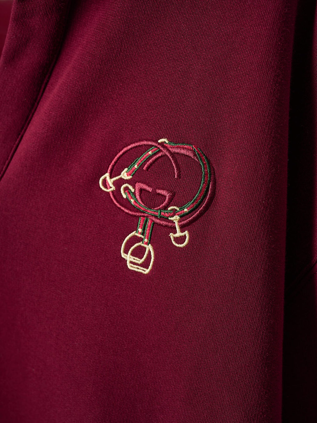 Gold-tone crest embroidery on burgundy polo sweatshirt