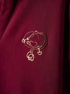 Gold-tone crest embroidery on burgundy polo sweatshirt
