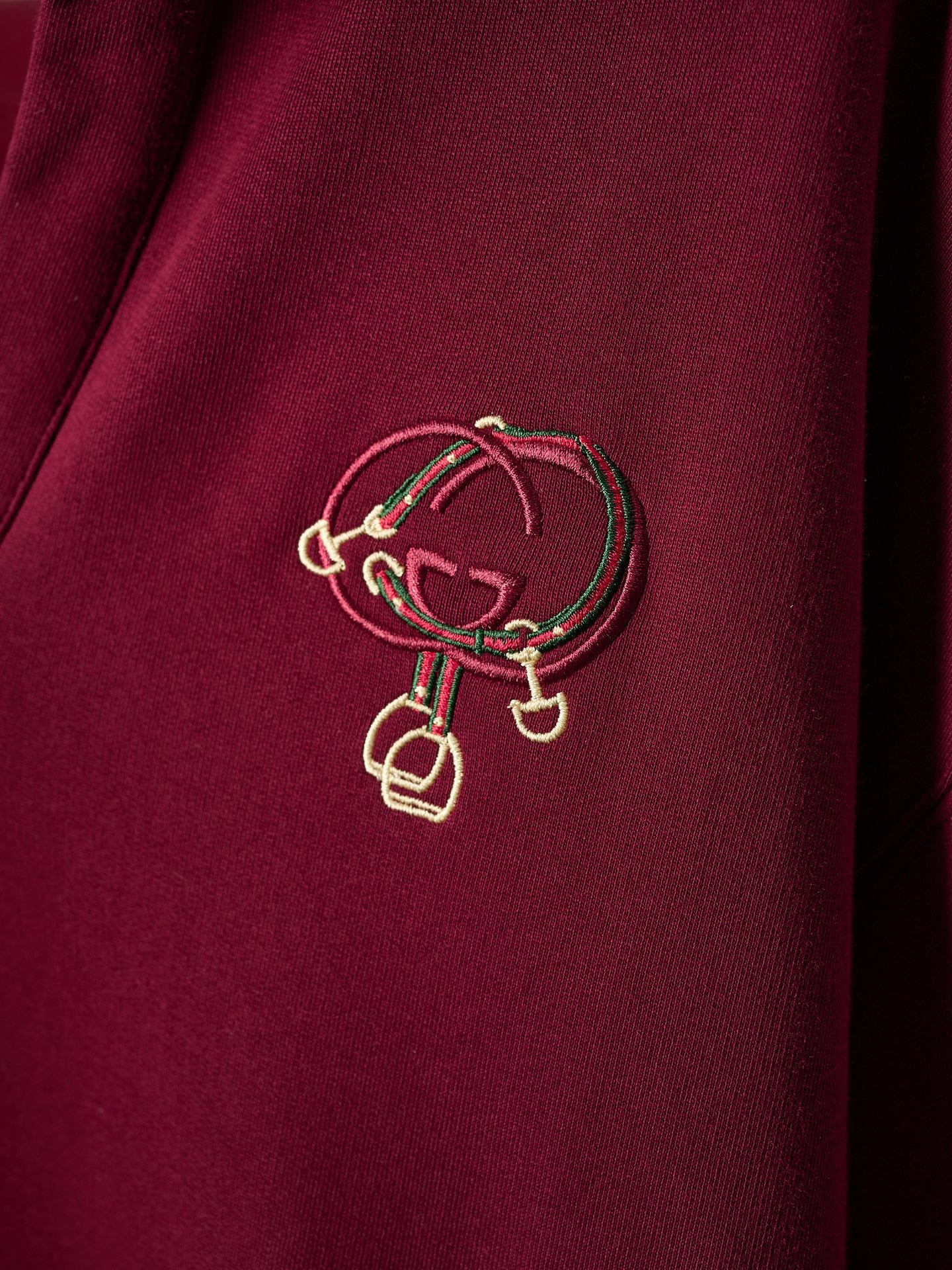 Gold-tone crest embroidery on burgundy polo sweatshirt