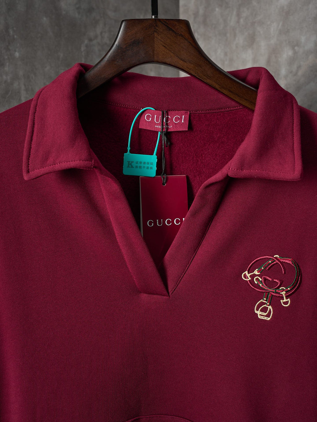 Burgundy polo sweatshirt with embroidered crest logo at chest