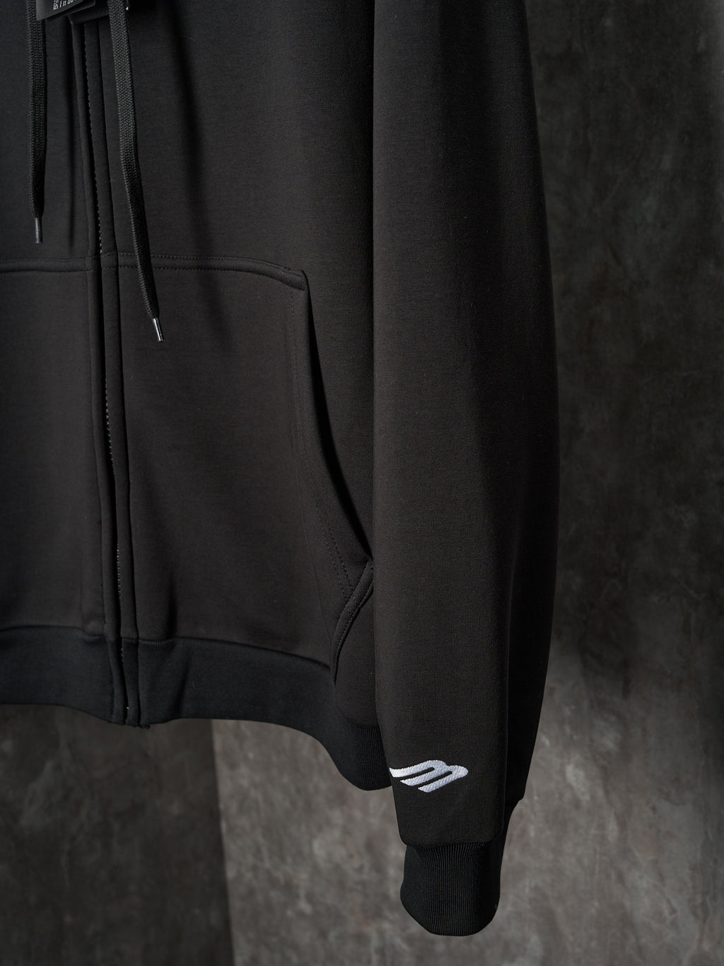 Black Balenciaga hoodie sleeve with small logo patch at cuff