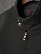Long jacket collar detail in dark GG pattern with snap button and zipper