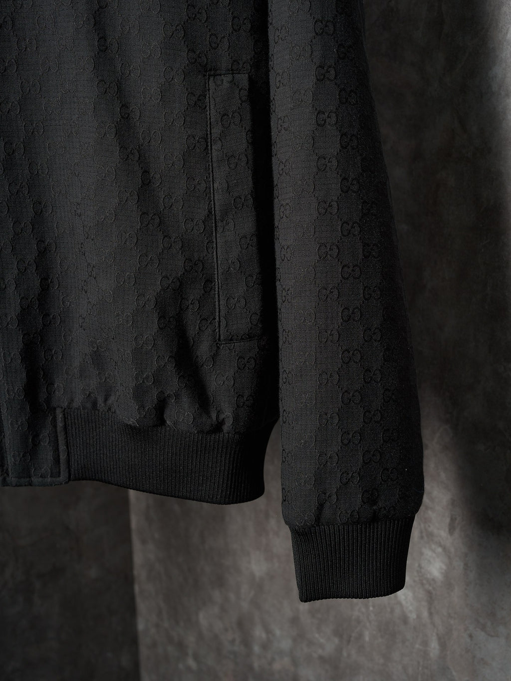 Long jacket sleeve and hem in dark allover GG pattern with ribbed cuff
