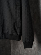 Long jacket sleeve and hem in dark allover GG pattern with ribbed cuff