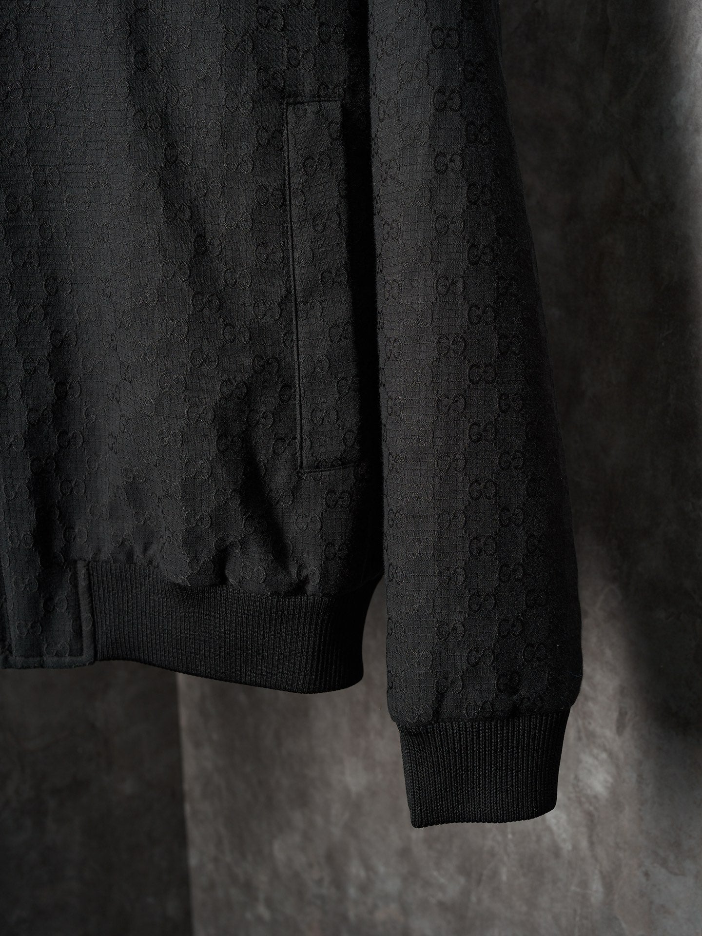 Long jacket sleeve and hem in dark allover GG pattern with ribbed cuff