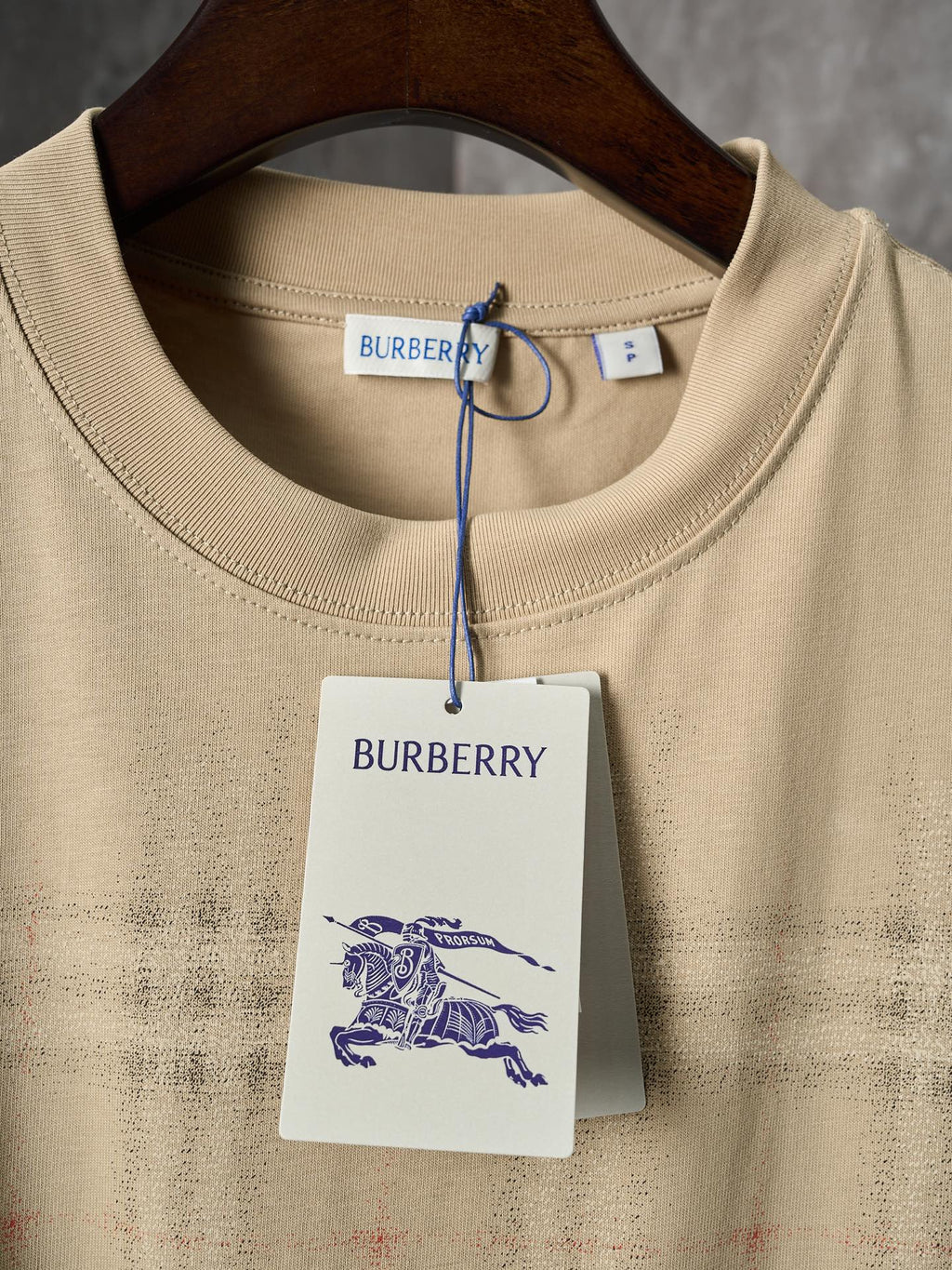 Beige crew-neck short-sleeve T-shirt with Burberry tag and blue tie at neck