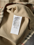 Beige T-shirt interior neck label with Burberry text on a white tag