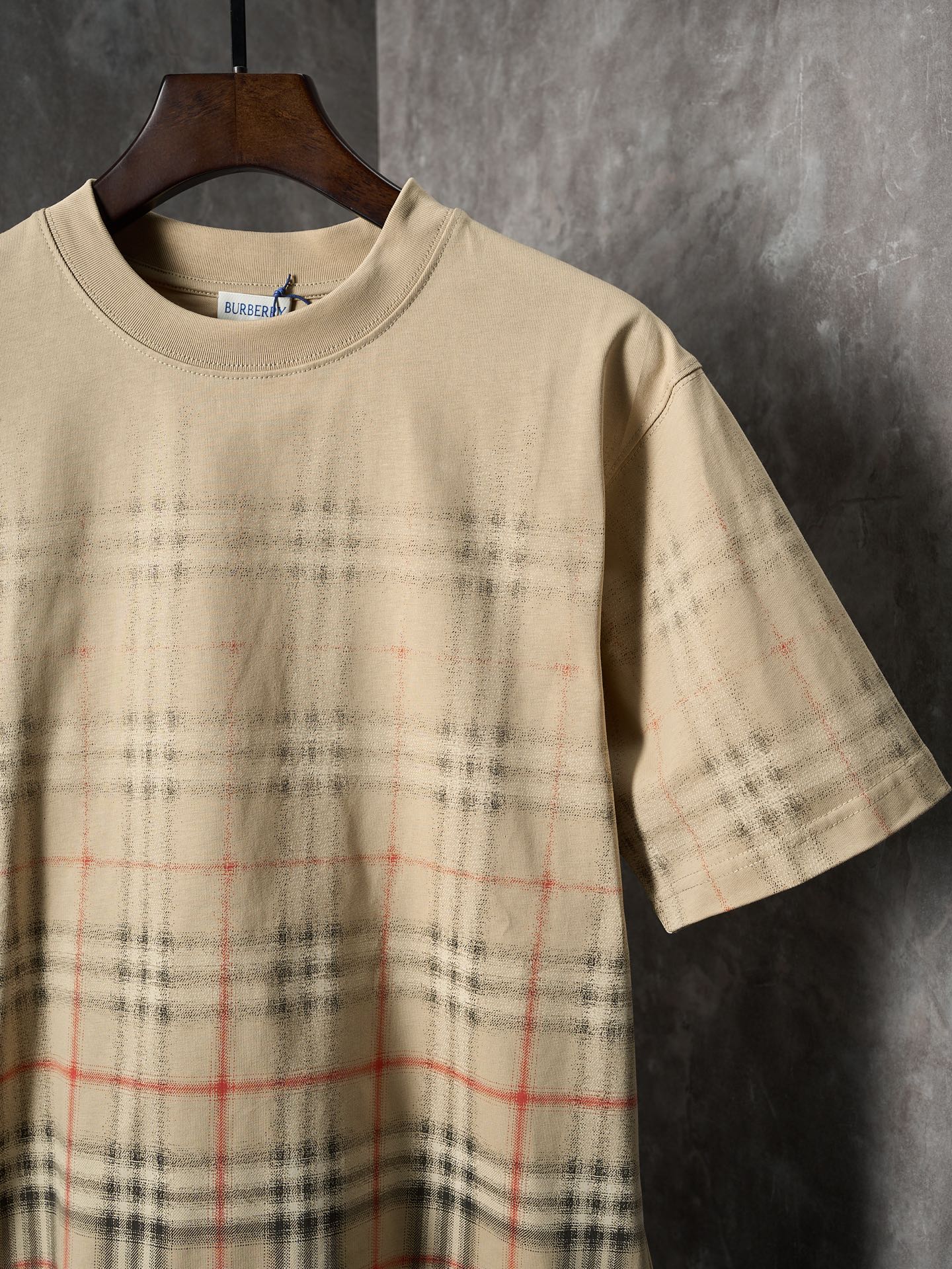 Beige short-sleeve T-shirt with crew neck and check plaid print at lower front