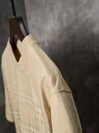 Beige short-sleeve T-shirt side view with subtle check plaid at the lower section