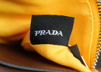 Mustard bag inner label with black fabric patch and Prada logo near zipper