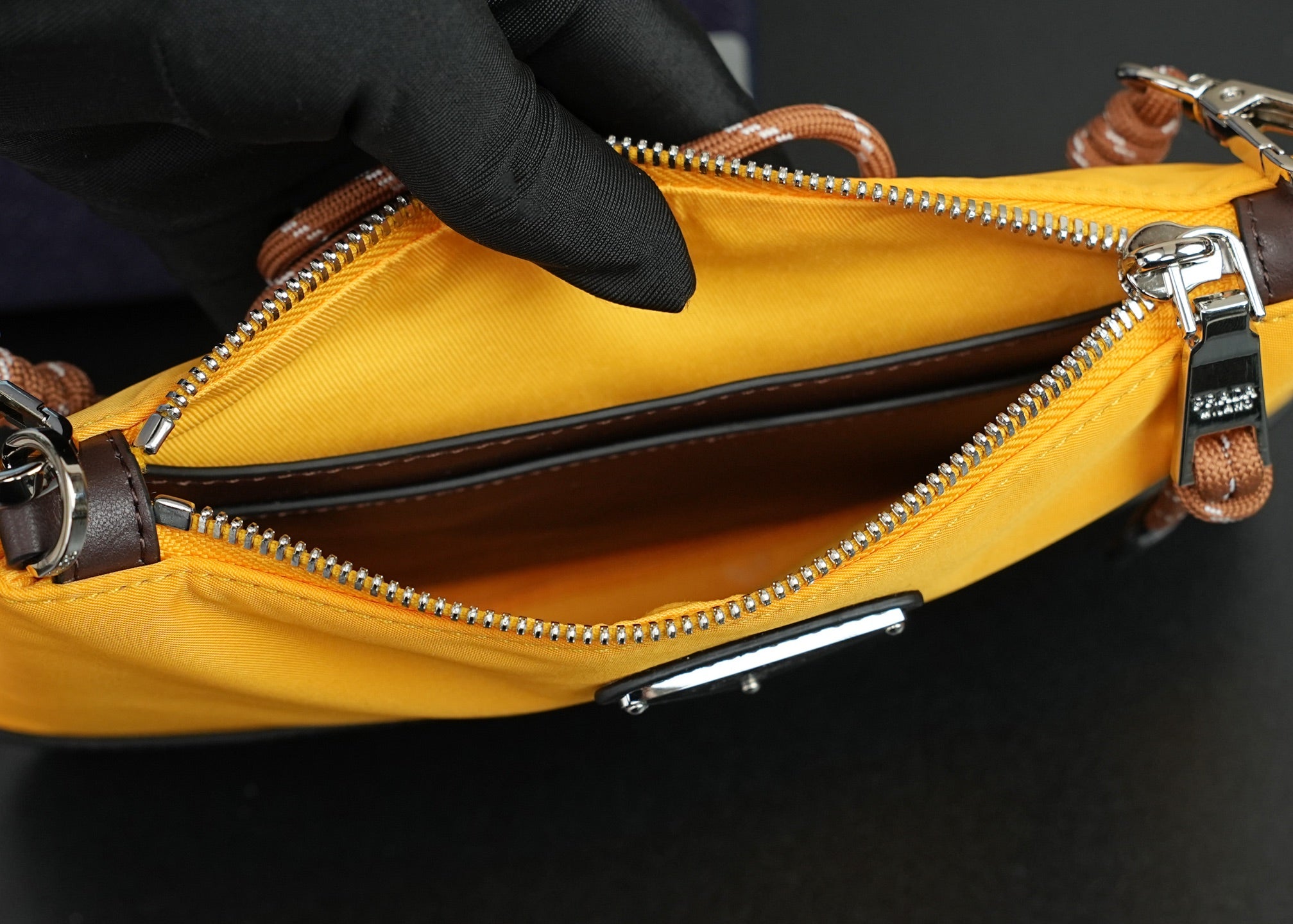 Mustard bag interior with zipper track, silver hardware, and brown edge trim