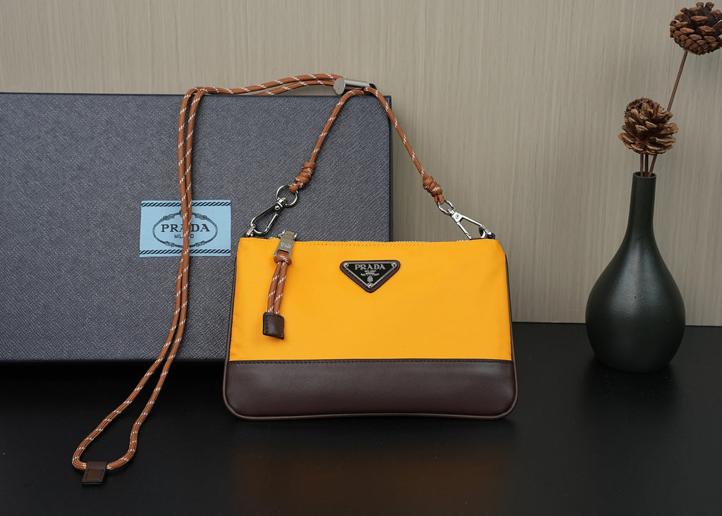 Two-tone mustard and brown crossbody bag with braided shoulder strap and logo plaque