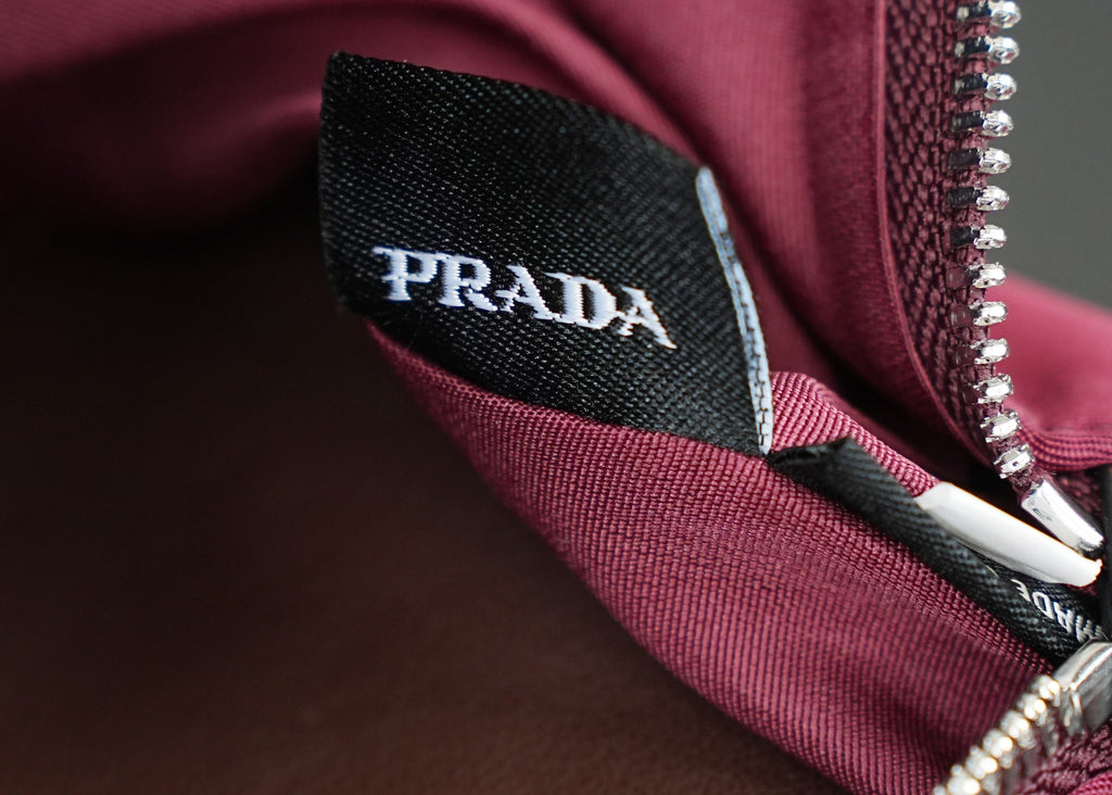 Prada fabric label inside Prada handbag near zipper, on magenta lining