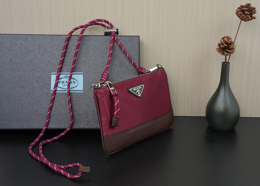Prada handbag in magenta with braided shoulder strap and triangular logo plaque