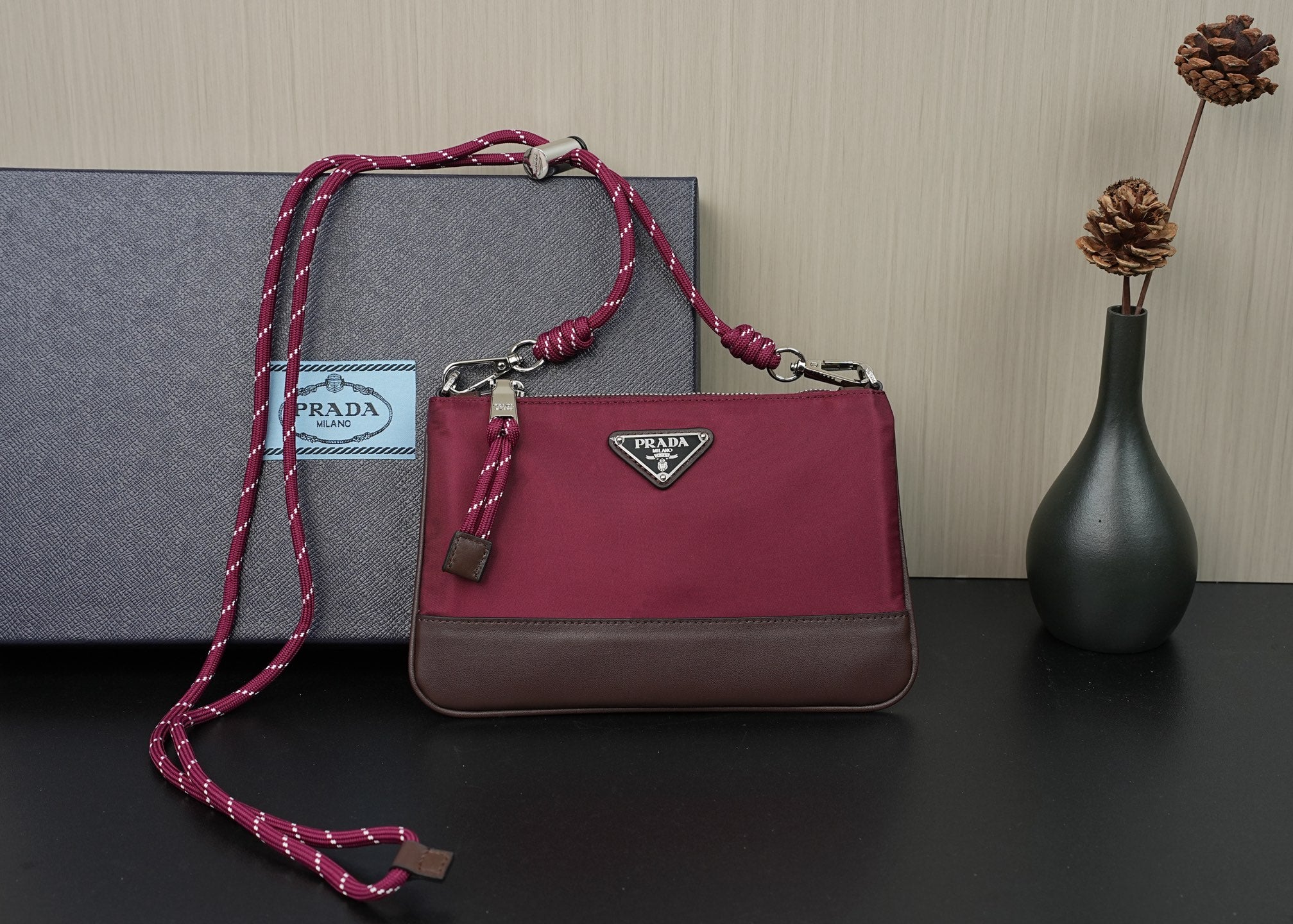 Prada handbag with magenta top handle, braided strap, and silver hardware