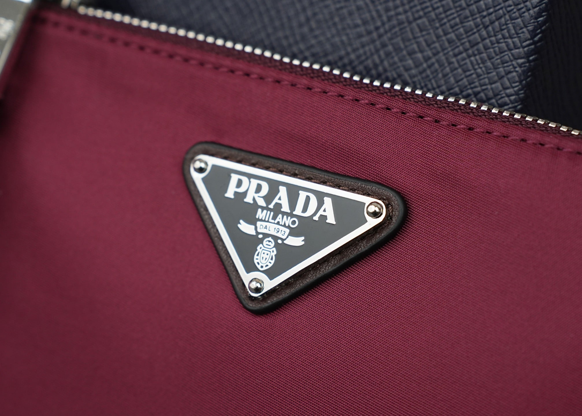 Prada handbag front triangle logo plaque on magenta fabric