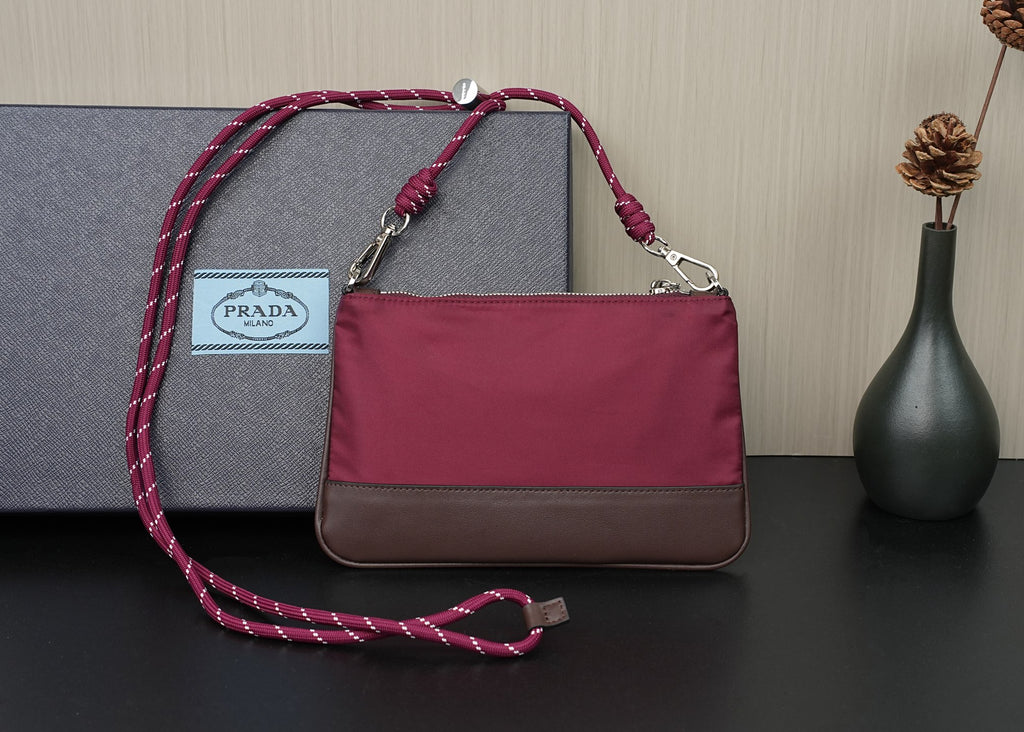Prada handbag with magenta body, braided crossbody strap, and top handles