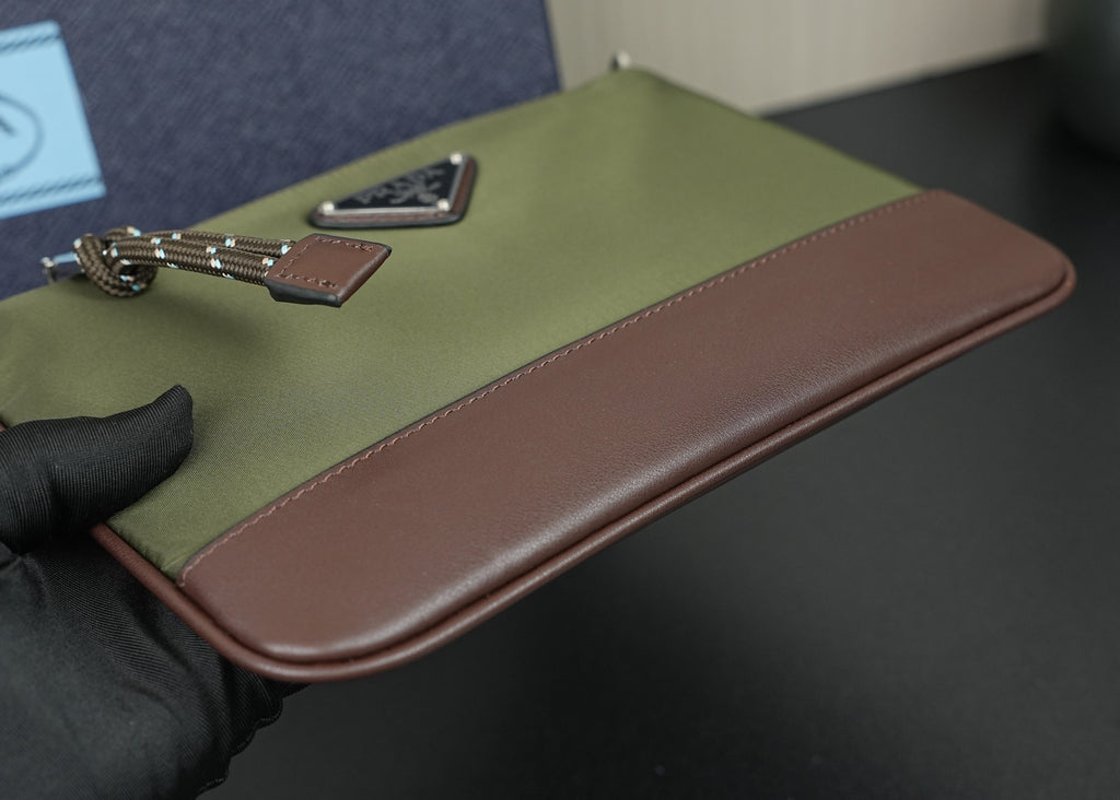 Prada bag close-up of olive flap with brown leather edge and chain hardware