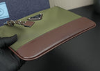Prada bag close-up of olive flap with brown leather edge and chain hardware