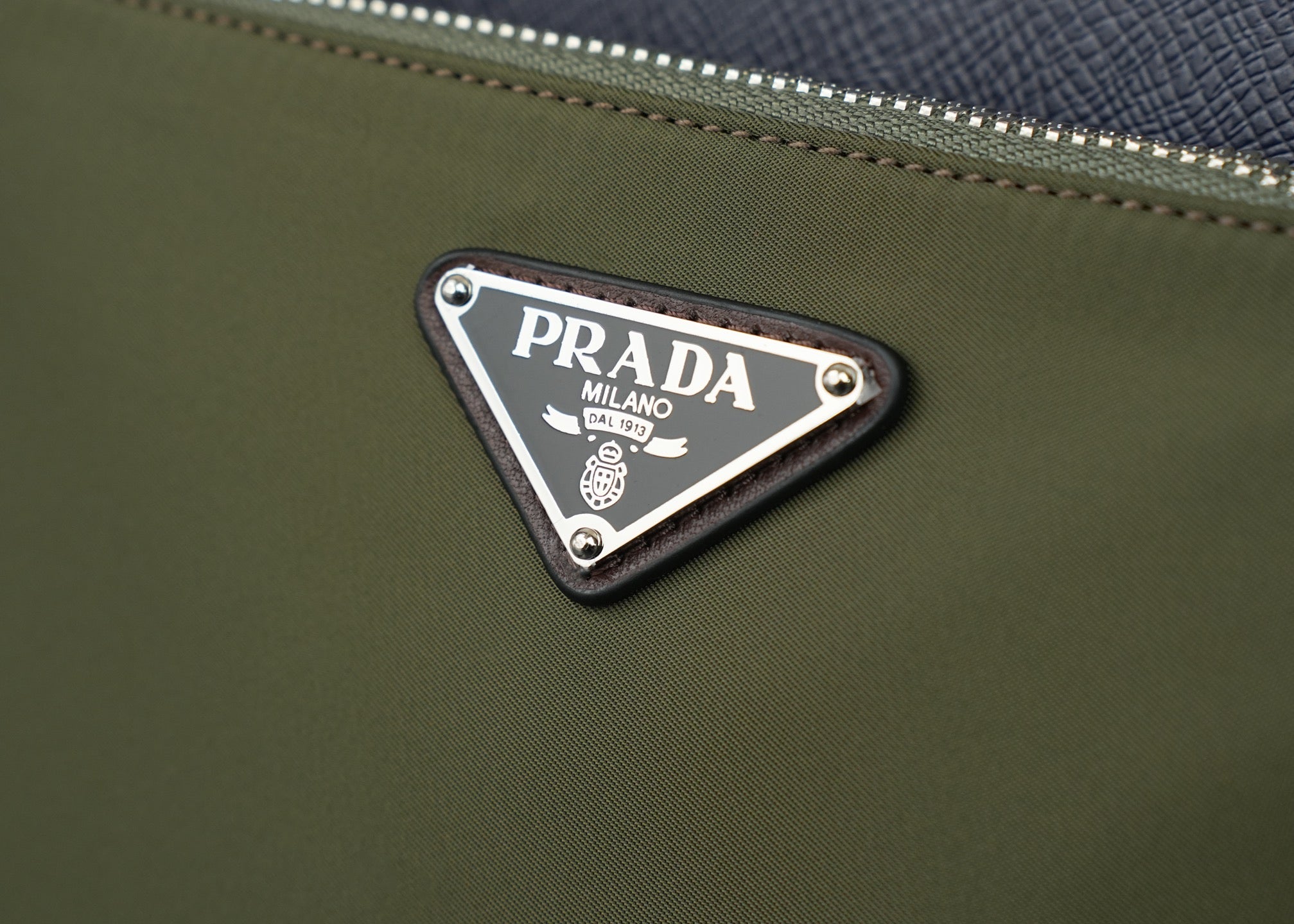 Prada logo plaque on olive fabric bag with silver studs and trim