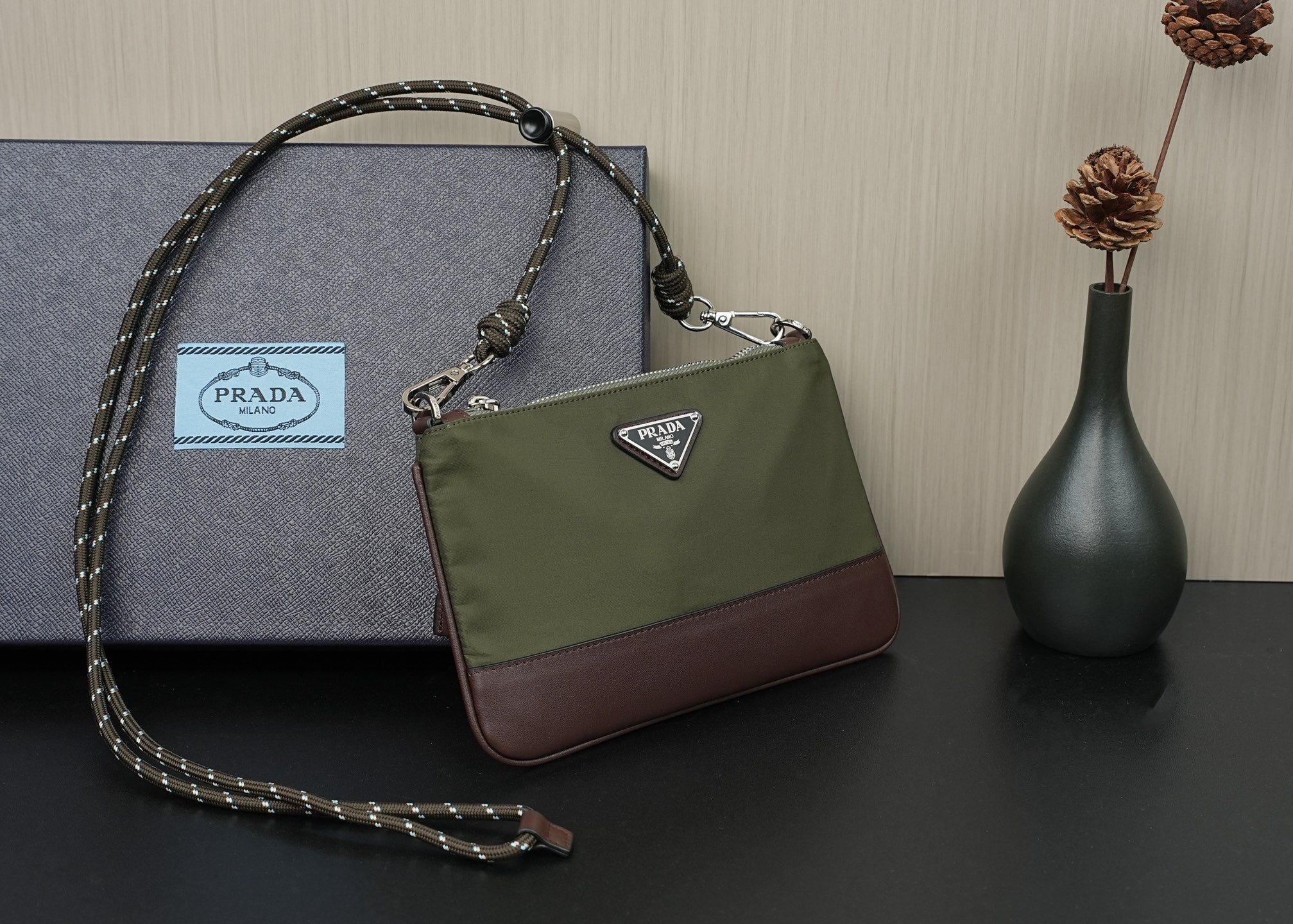 Prada bag with olive body, brown trim, and metal logo on flap