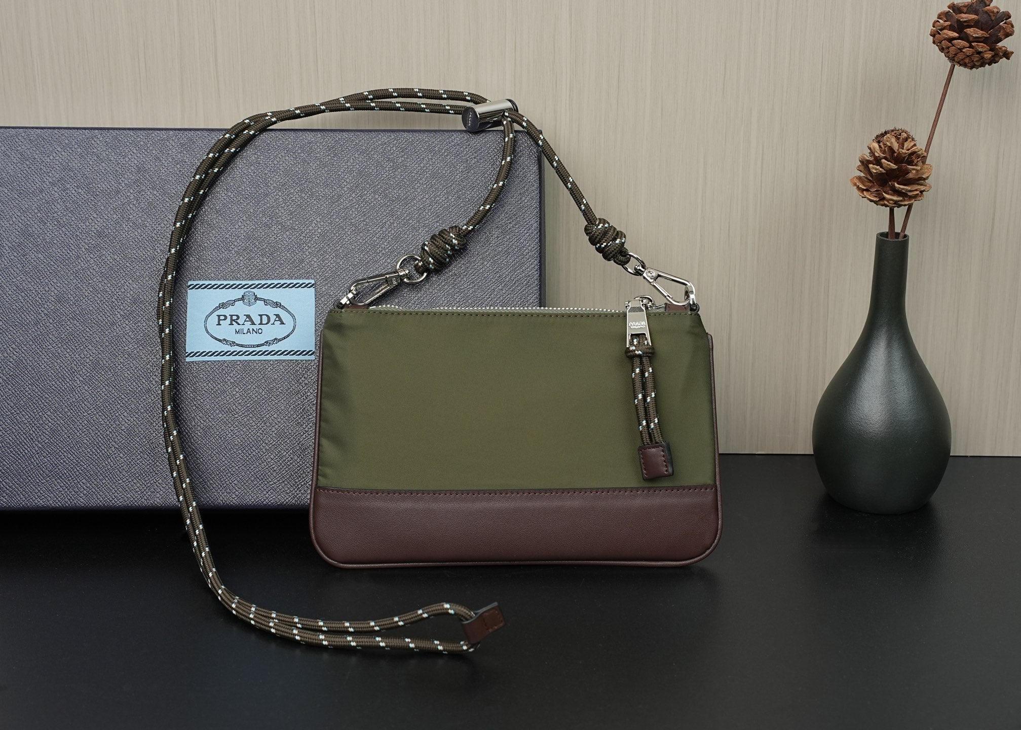 Prada bag side view with olive panel, brown base, and chain strap