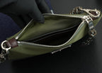 Prada bag interior view with zipper, olive lining, and brown leather tabs