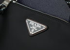 Prada metal logo plate on black textured bag with zipper and stitched edge