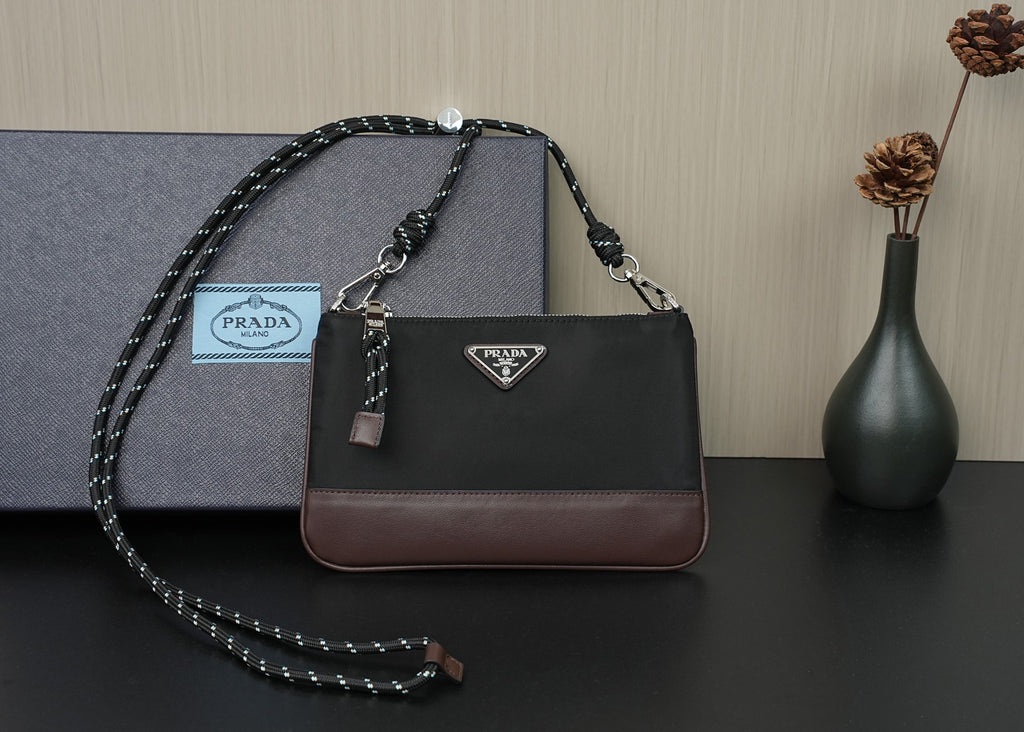 Prada shoulder bag in black with brown trim, silver-tone hardware and chain strap