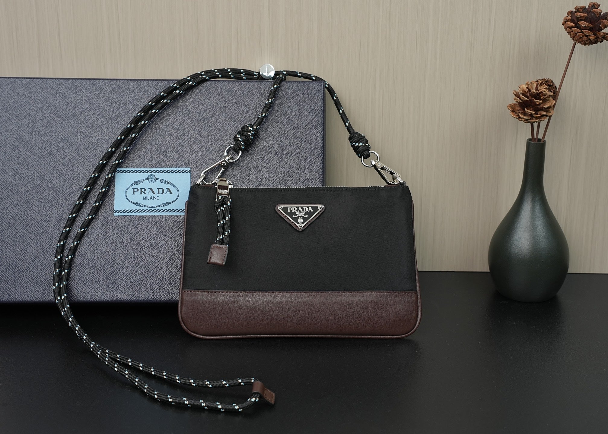 Prada shoulder bag in black with brown trim, silver-tone hardware and chain strap