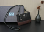 Prada shoulder bag with top handle, black body and brown base trim, chain crossbody strap