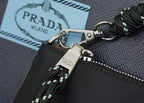 Prada strap hardware with braided black cord, silver clasp and logo tag on bag