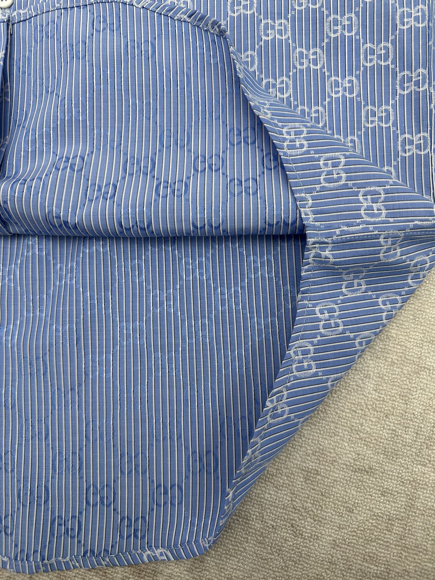 Blue Gucci shirt cuff and sleeve with vertical stripe and GG trim detail